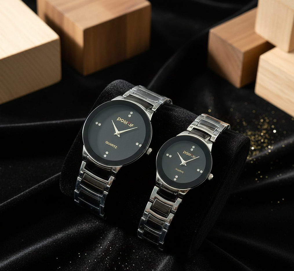 Two silver watches on a black fabric background with wooden blocks.